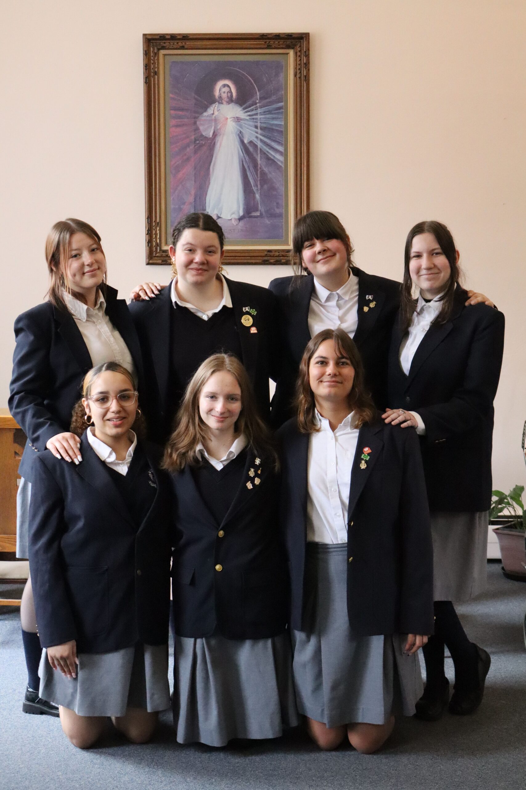 Students posing in front of photo of Jesus